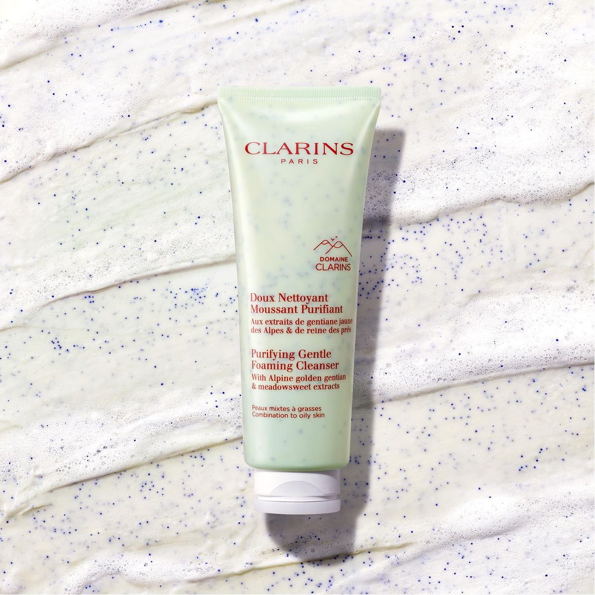 Clarins cleanser bottle beside a coin for size comparison and portability benefit