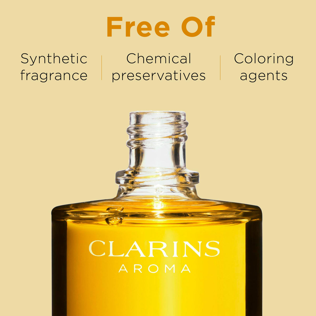 Clarins bottle beside a hand to show product scale and travel-friendliness