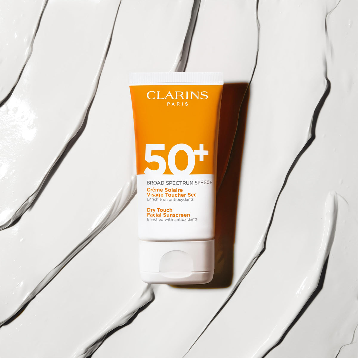 Clarins sunscreen layered under makeup showing compatibility and even foundation finish