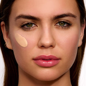 Clarins UV Plus being applied to cheek demonstrating even tint and blendability benefit