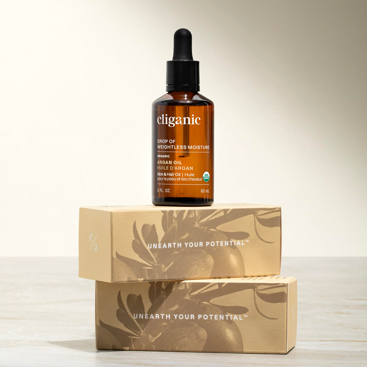 Cliganic argan oil bottle beside common objects to show size