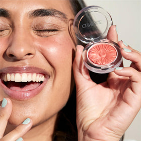 Clinique open compact with brush demonstrating easy application on cheeks