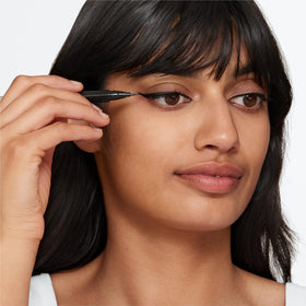 Clinique eyeliner held in hand to show compact pen size and travel convenience