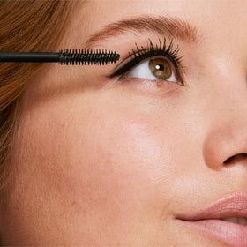 Clinique mascara placed inside a makeup bag illustrating travel ready waterproof performance