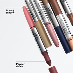 Clinique dual-ended stick beside a makeup bag showing travel-ready convenience