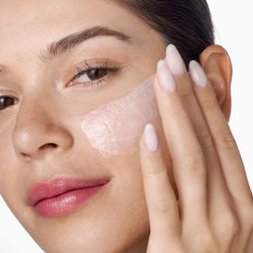 Clinique Moisture Surge jar in hand to show 3.4 fl oz scale and convenient size