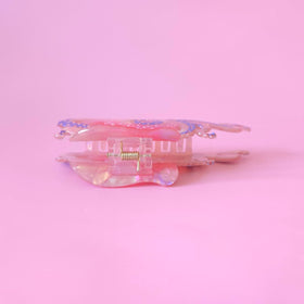 Clip Sugar size comparison beside a hand shows compact scale