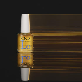 CND LIGHTNINGOIL bottle on vanity with citrus accents, conveys energizing scent benefit