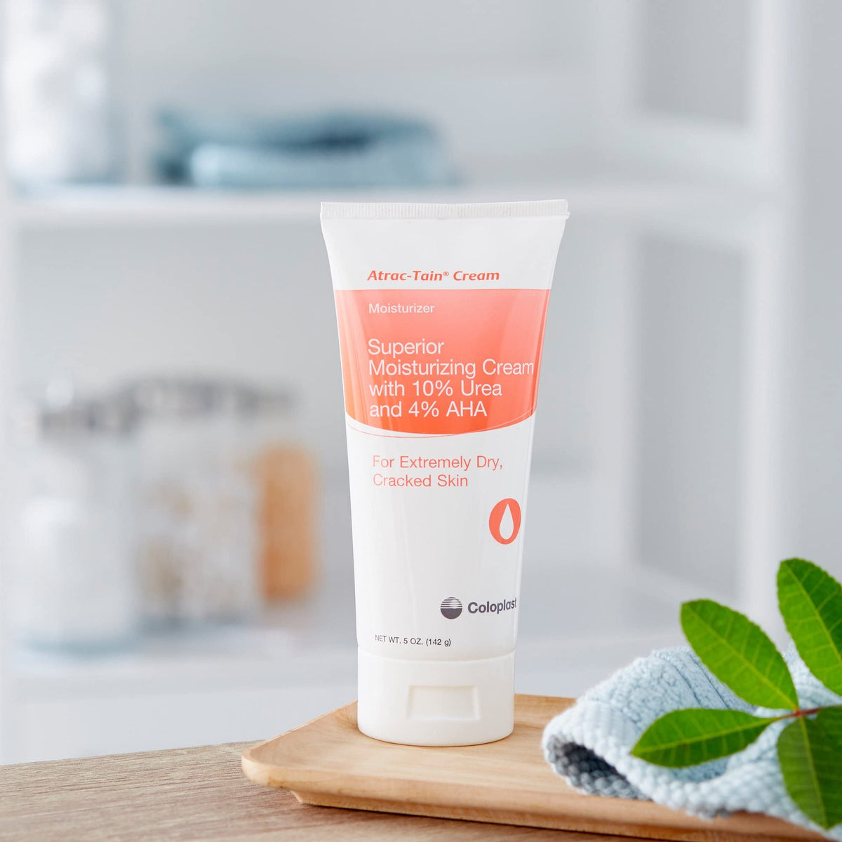 Coloplast Atrac-Tain held in hand for size comparison showing travel-friendly 5 oz convenience