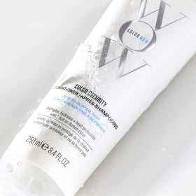 COLOR WOW in hand scale comparing travel-friendly 2.5 fl oz for portability