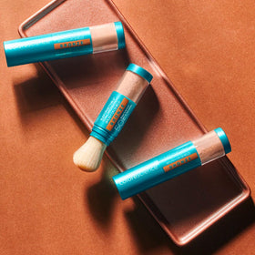 Colorescience applying bronze powder over makeup for quick mid‑day touch-ups