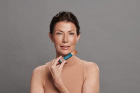 Colorescience brush held in hand to show compact size and travel convenience