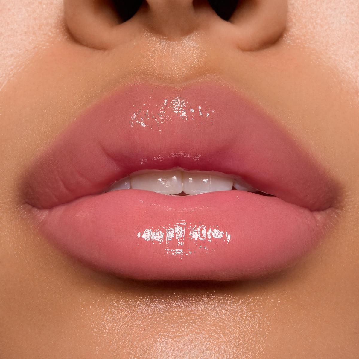 ColourPop gloss on model lips demonstrating sheer baby pink glossy effect