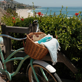 COOLA on a beach towel illustrating outdoor sun protection