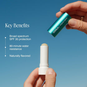 COOLA Liplux held in hand for scale and portable daily protection
