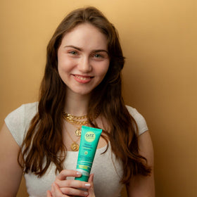 Model applying CoTZ to face illustrating smooth, non-greasy feel