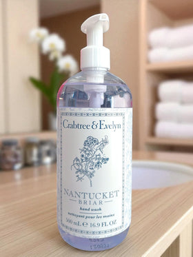 Crabtree & Evelyn bottle held in hand to show 16.9 fl oz size and home sink suitability