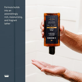 Cremo bottle held in hand to show 16 fl oz scale for value