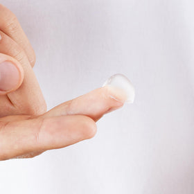 Cremo pomade being scooped onto hands for easy application benefit