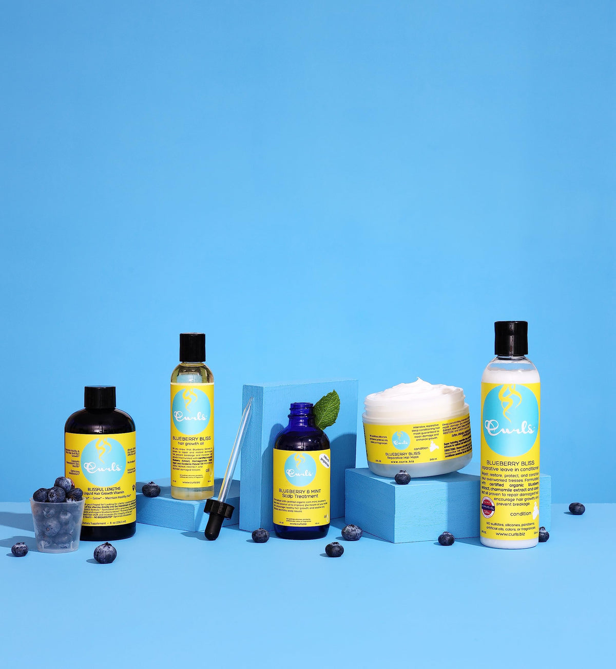 Curls Blueberry Bliss applied to curls in hand demonstrating detangling benefit