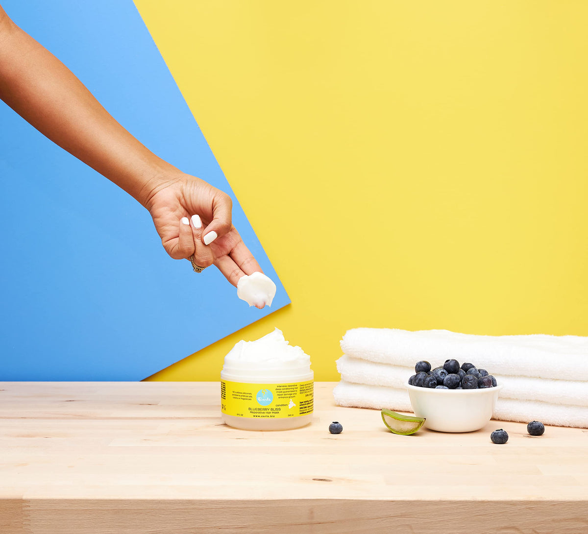 Curls blueberries and aloe ingredients staged to highlight botanical formulation benefits