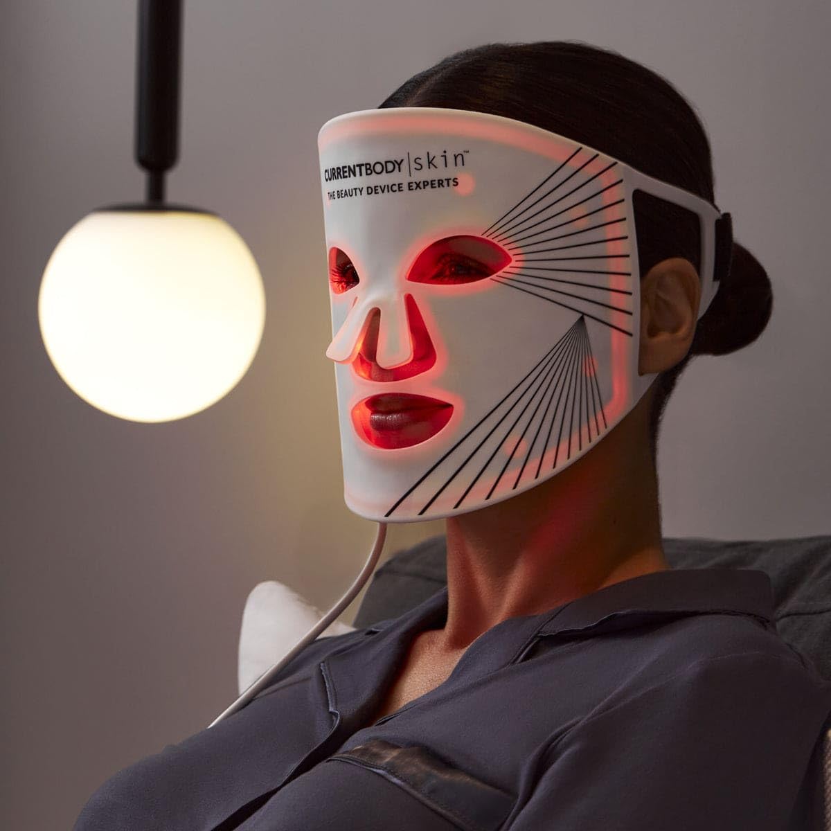 CurrentBody mask beside a hand to show scale and portability benefit