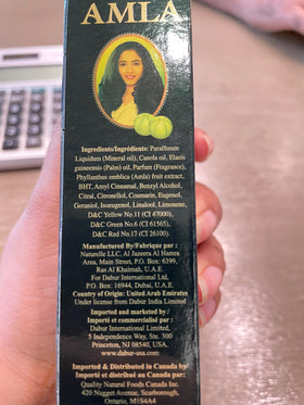 Dabur Amla Hair Oil on bathroom shelf in lifestyle setting for routine use