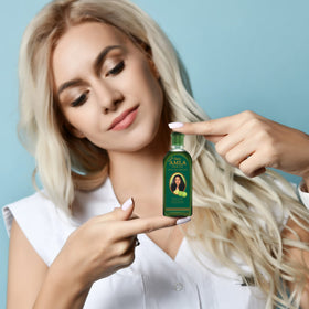 Dabur Amla Hair Oil held in hand to show 200ml size and scale