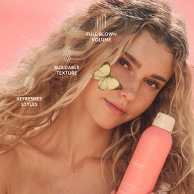 Bottle with citrus and blossom props illustrating DAE scent profile and fresh aroma benefit