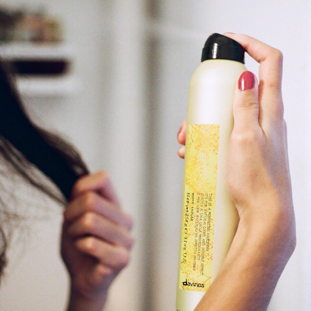Davines hair in use with stylist spraying for natural movement and finish