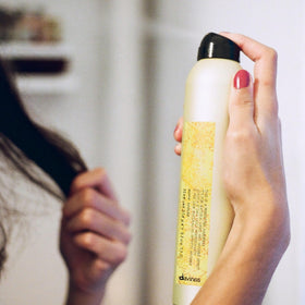 Davines hair in use with stylist spraying for natural movement and finish