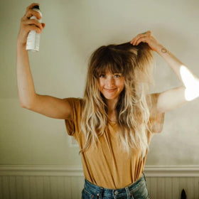 Davines bottle in hand showing 5.07 fl oz size for travel convenience