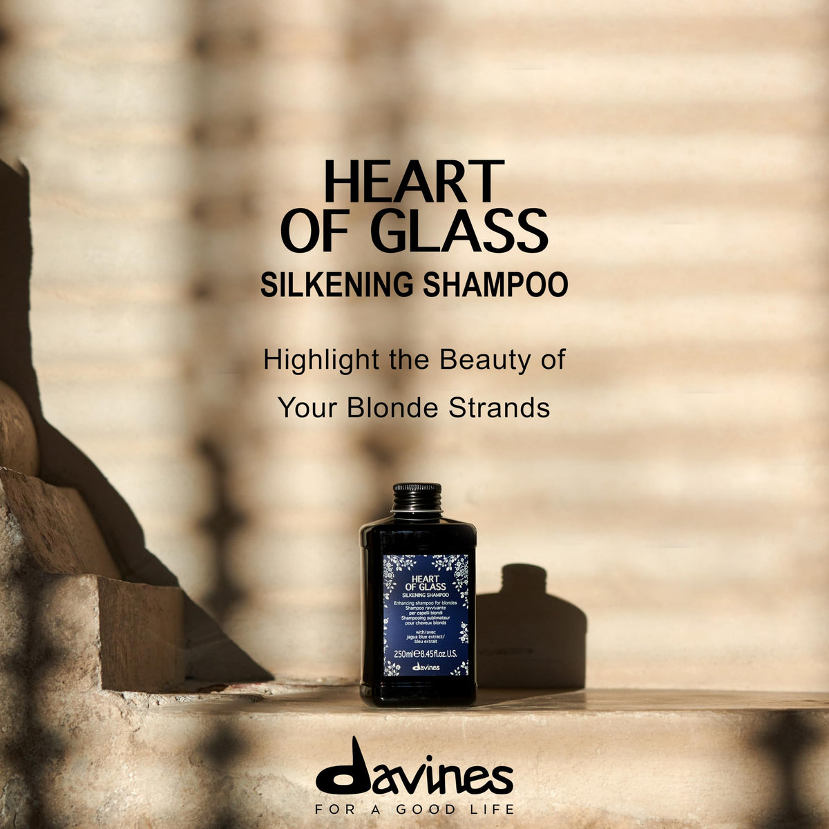 Davines Heart of Glass bottle held in hand to show 8.45 fl oz scale and portability benefit