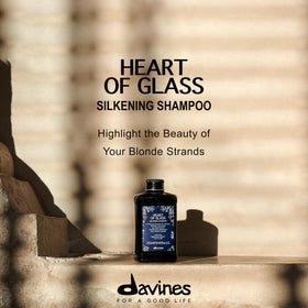 Davines Heart of Glass bottle held in hand to show 8.45 fl oz scale and portability benefit