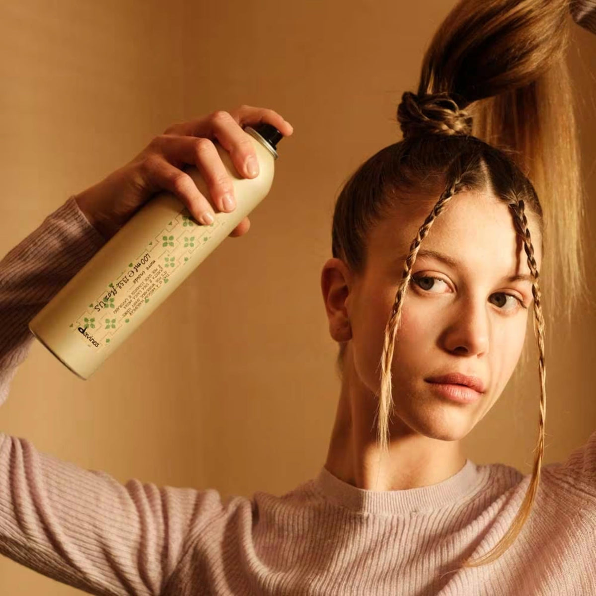 Davines being sprayed onto styled hair to lock shape and reduce frizz