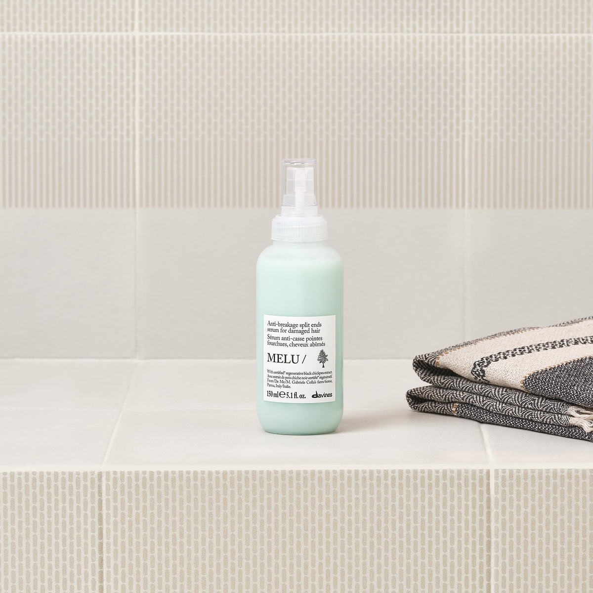 Applying Davines MELU/Serum to midlengths and ends for smoother hair benefit
