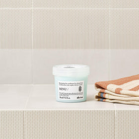 Davines MINU conditioner label detail highlighting ingredient and quality benefit