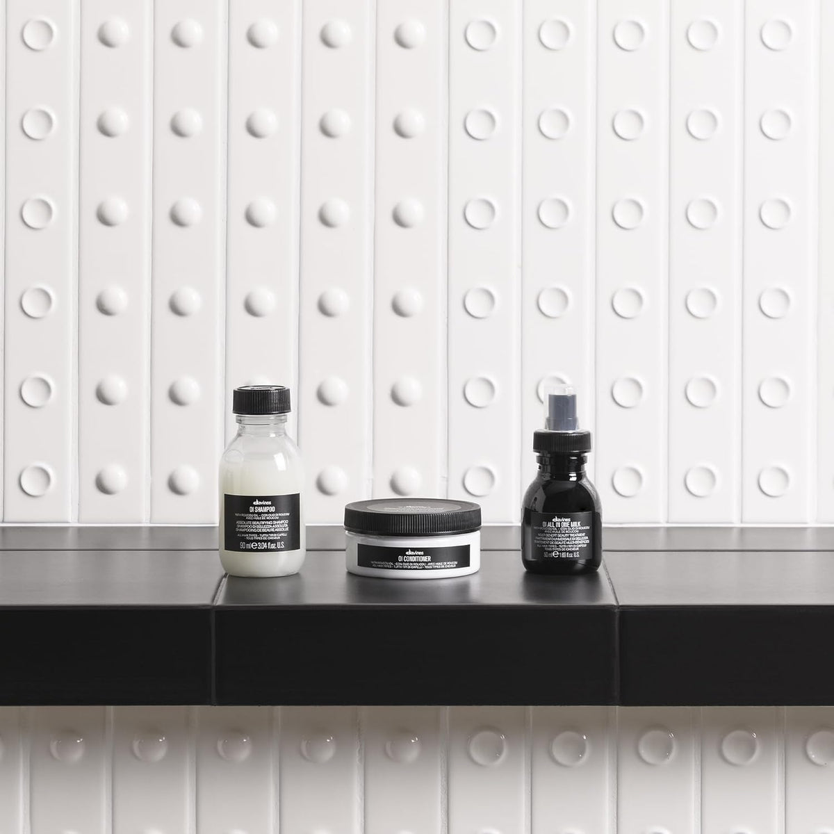 Davines OI milk being applied to damp hair showing detangling and smoothing benefit