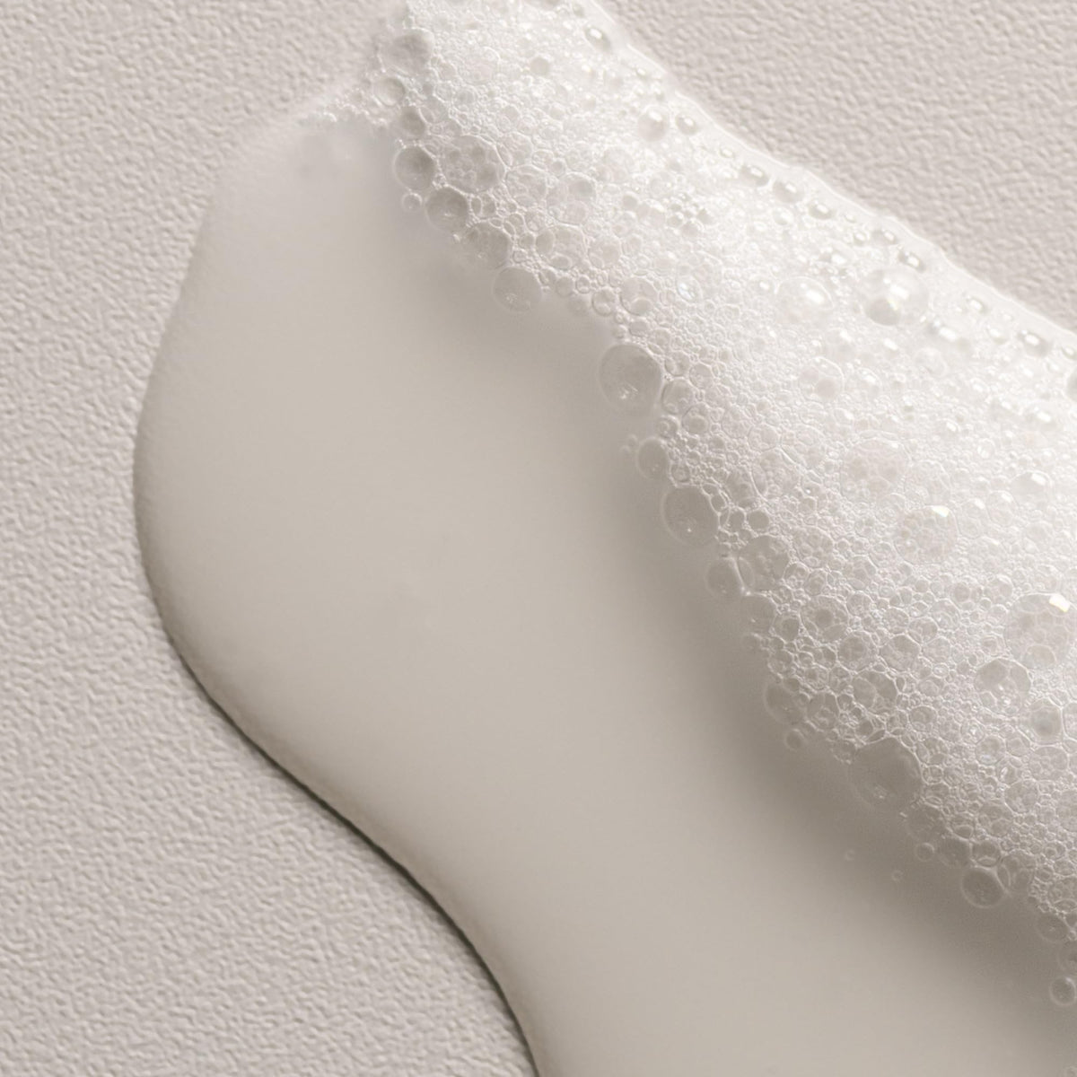 Davines OI shampoo forming creamy lather, showing effective gentle cleansing benefit