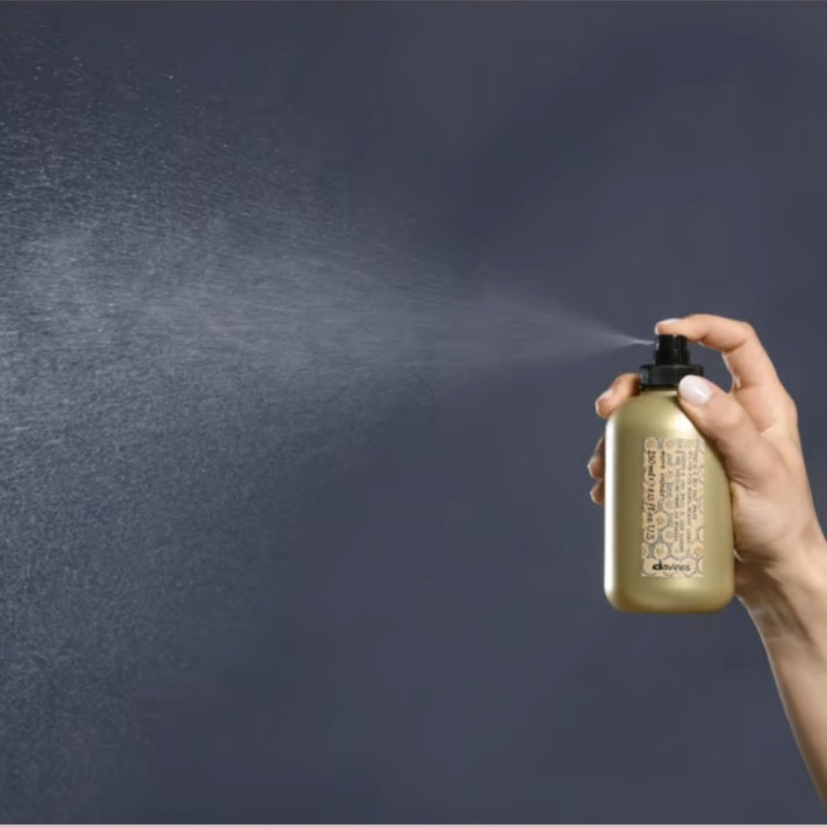 Davines bottle in hand for size and portability benefit