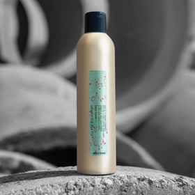 Davines strong hairspray mid-air spray action demonstrating fine mist hold