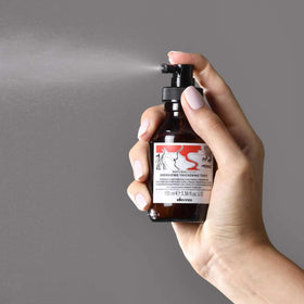 Davines travel-size bottle in hand for portability benefit