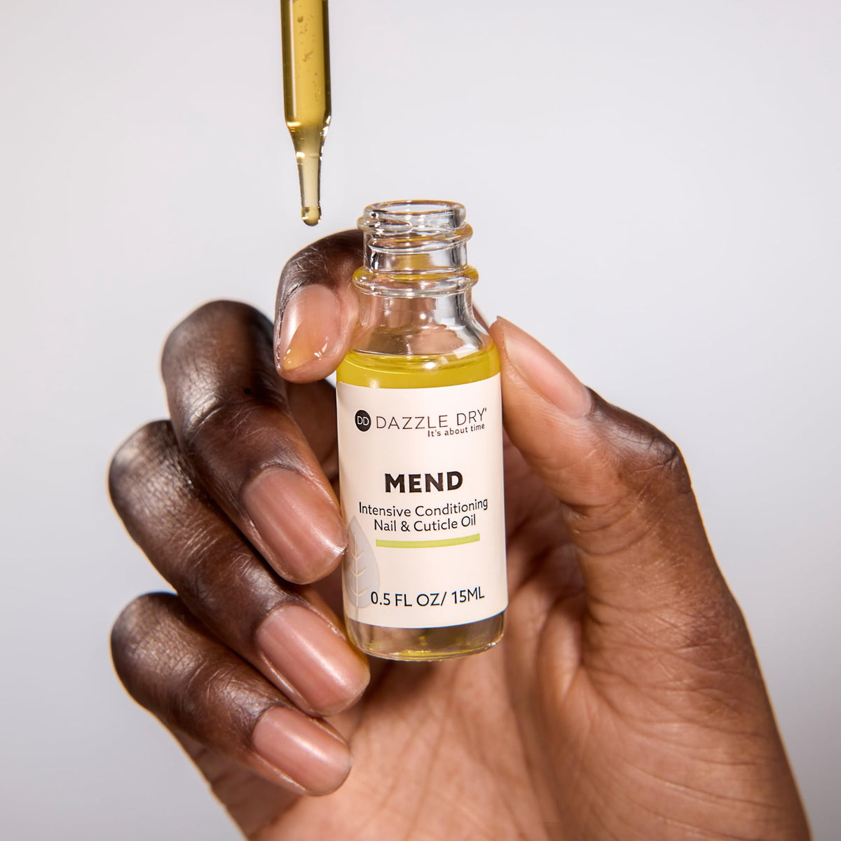 Dazzle Dry dropper applying oil to nail for quick hydration
