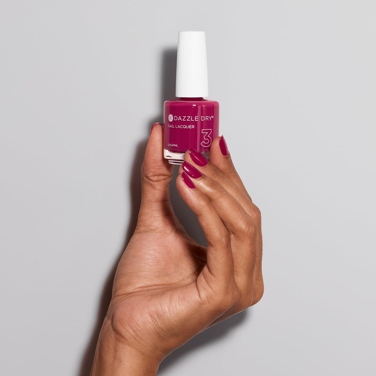 Raspberry Rush applied on natural nails in hand showing Dazzle Dry durable look