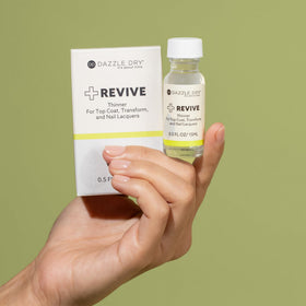Bottle being rolled between hands to mix Dazzle Dry Revive for even results
