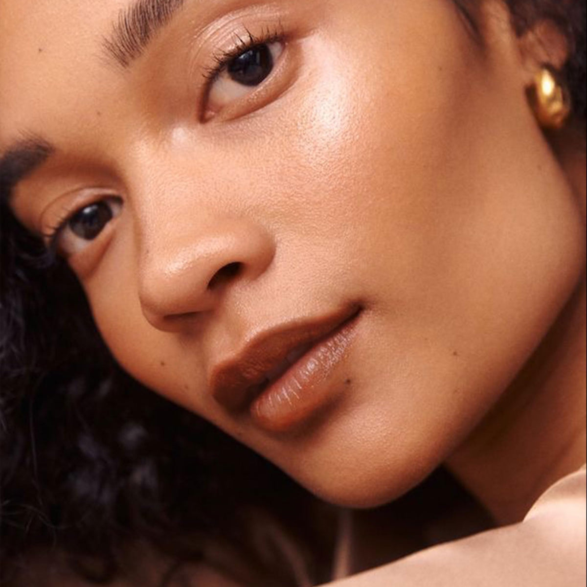 Depuplum lipstick applied on lips demonstrating natural brown tint and hydrated, radiant look