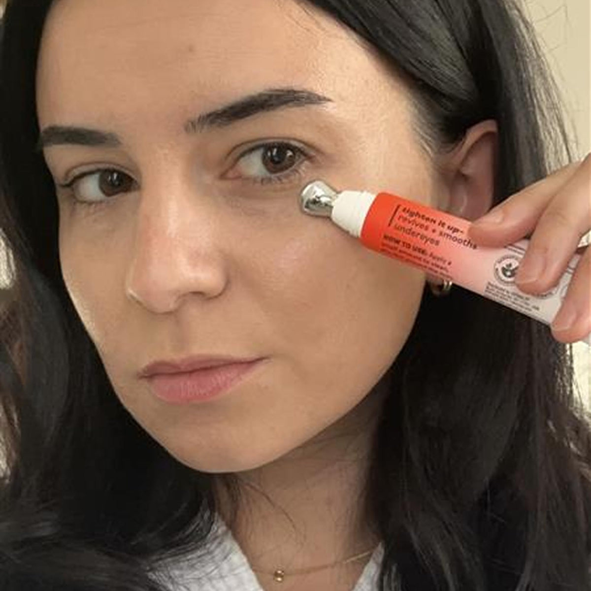 Derma E applying product under eye showing targeted treatment and cooling benefit