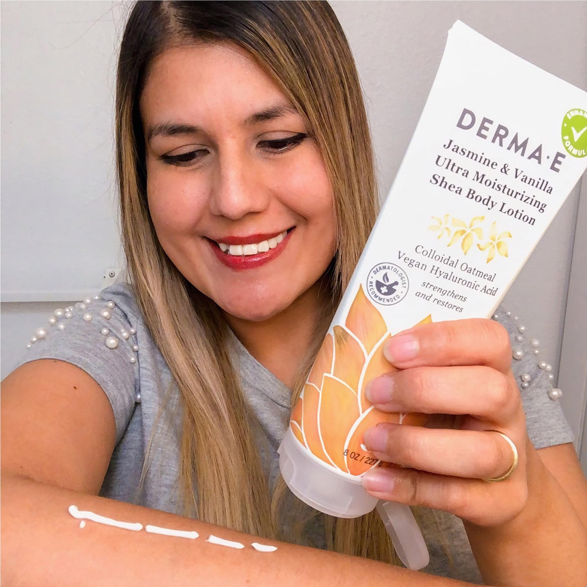 Derma E bottle surrounded by jasmine and vanilla flowers suggesting natural scent