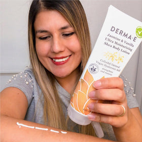 Derma E bottle surrounded by jasmine and vanilla flowers suggesting natural scent