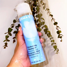 Derma E bottle held in hand for size comparison and travel-friendly 10 oz benefit